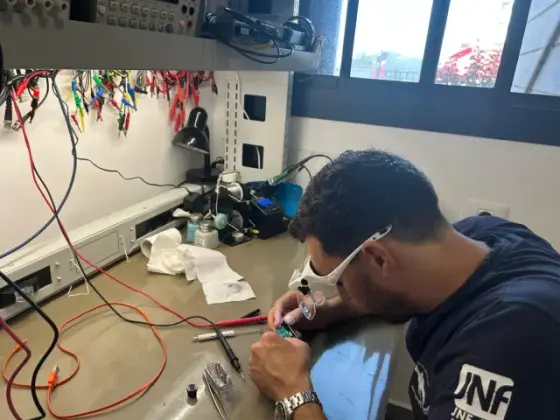 Engineer soldering a prototype circuit with magnifying glasses